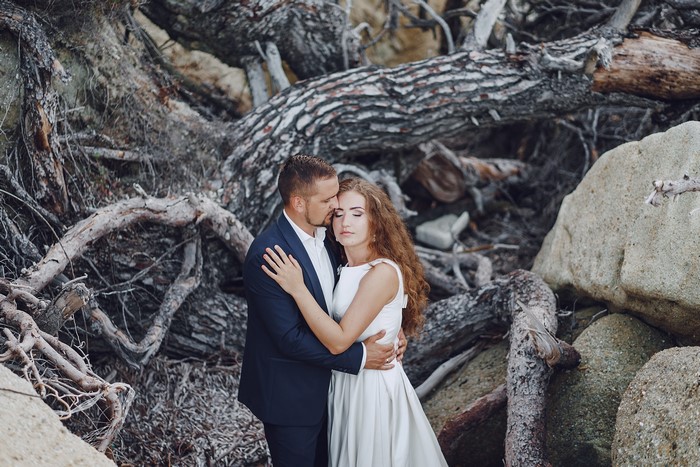 Bride and Groom hugging by a tree