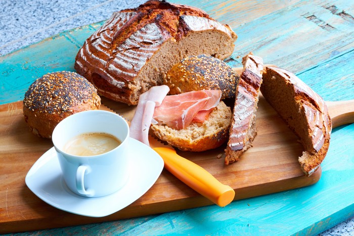 Bread, Buns, Ham, and Coffee on Cutting Board