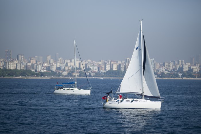 Two sailboats on the water with Istanbul skyline in the background