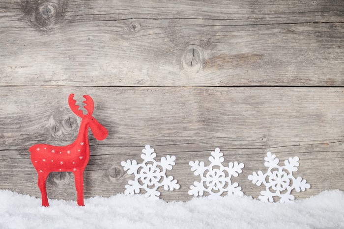 Red Christmas deer and snowflakes on wood planks