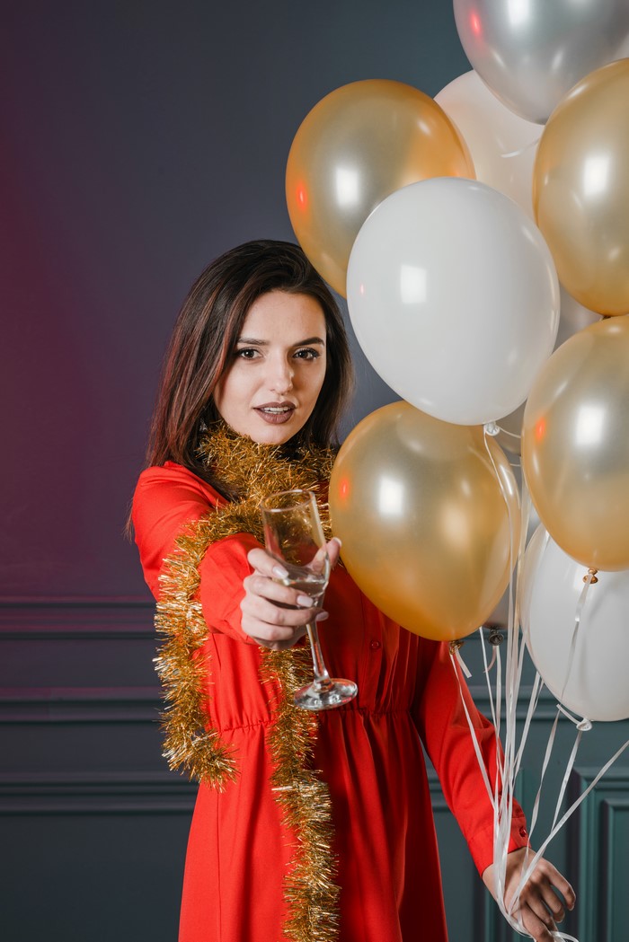 Woman holding champagne with balloons