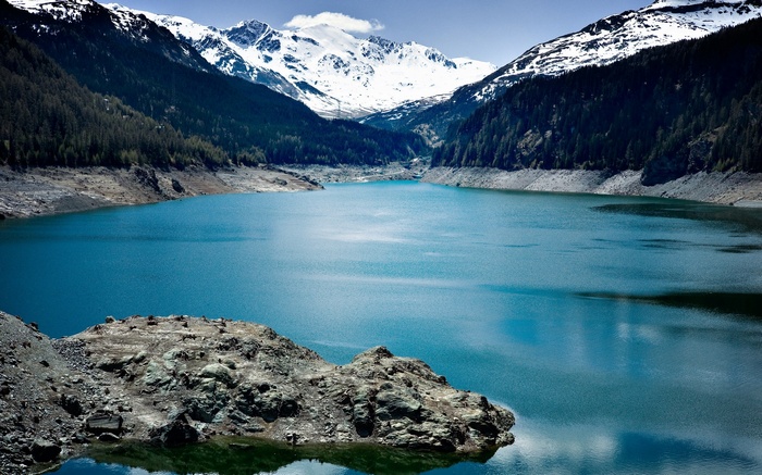 Turquoise lake surrounded by mountains and forests