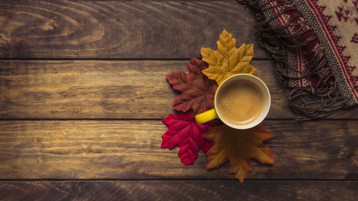 Autumn Coffee with Foliage and Scarf on Wood