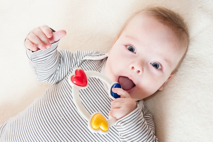 Infant playing with a toy rattle
