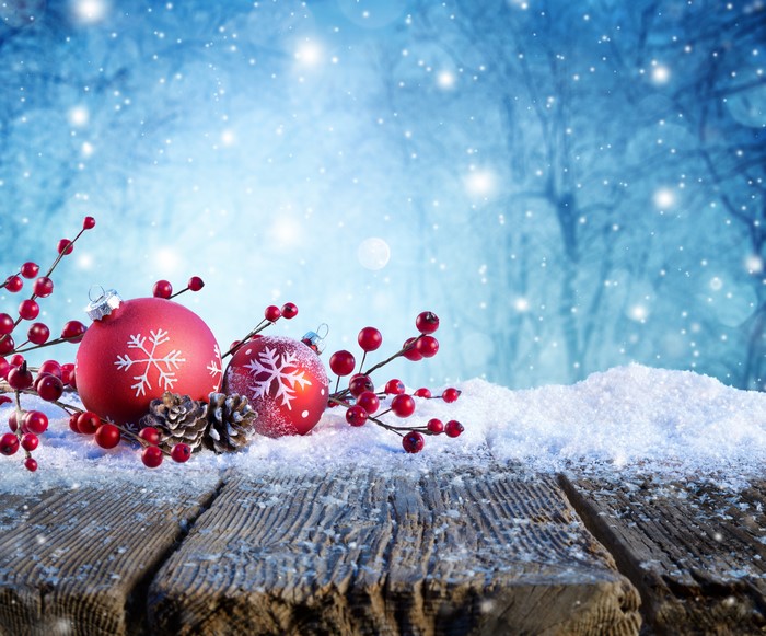 Christmas ornaments and berries on wooden planks with snow