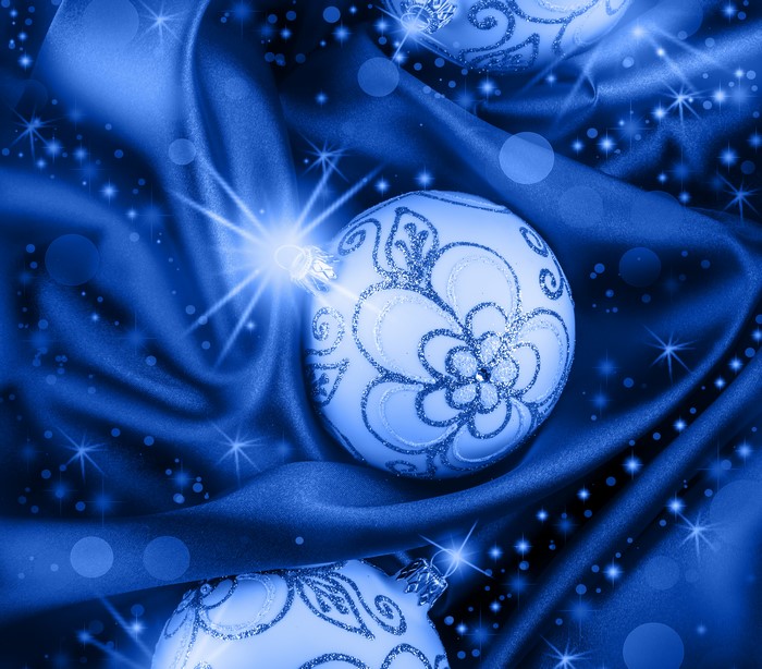 Christmas balls on blue silk with light rays