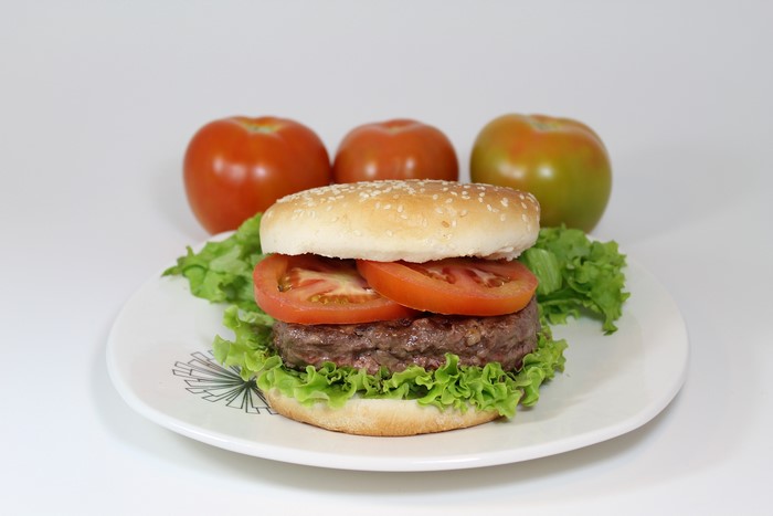 Hamburger with tomatoes and lettuce on a plate