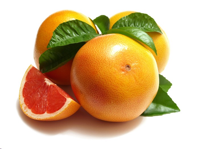 Grapefruits with leaves and slice on white background