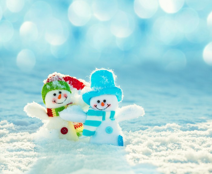 Two snowmen with hats and scarves in the snow