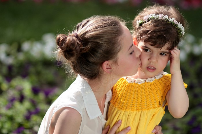 Two girls, one kissing the other