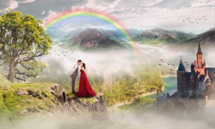 Couple in love near a castle with a rainbow