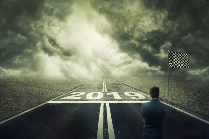 Man on road with 2019 and checkered flag