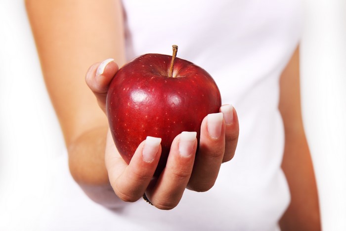 Hand holding a red apple