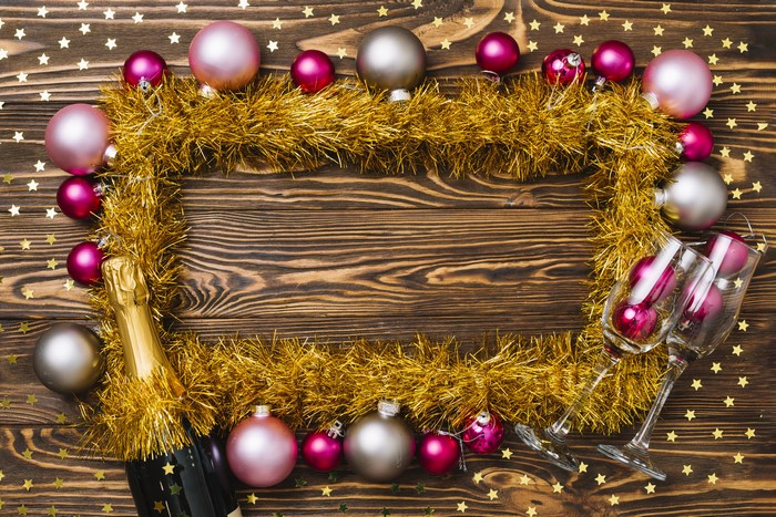 Christmas balls and champagne bottle on wooden background