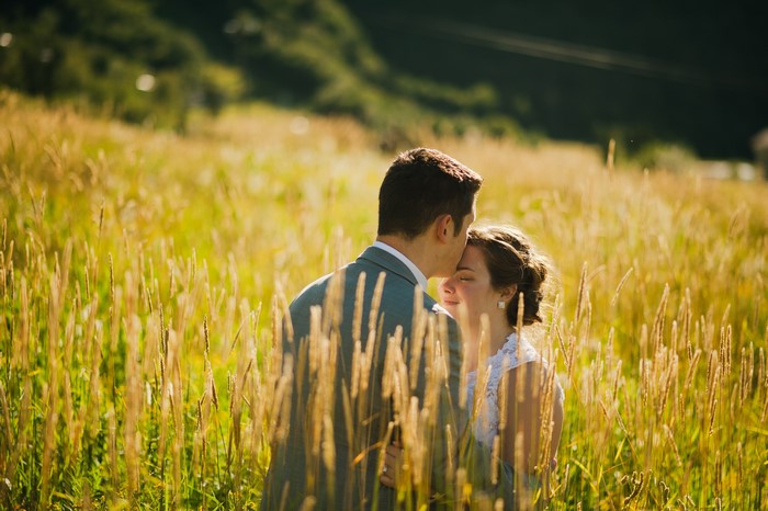 Couple kissing in a field of tall grass