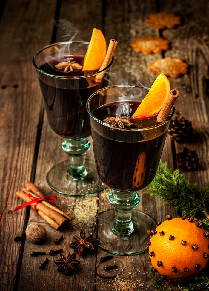 Mulled wine with orange and cinnamon on wooden table