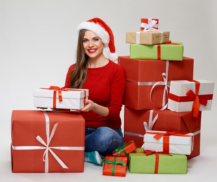 Woman in Santa hat with Christmas gifts