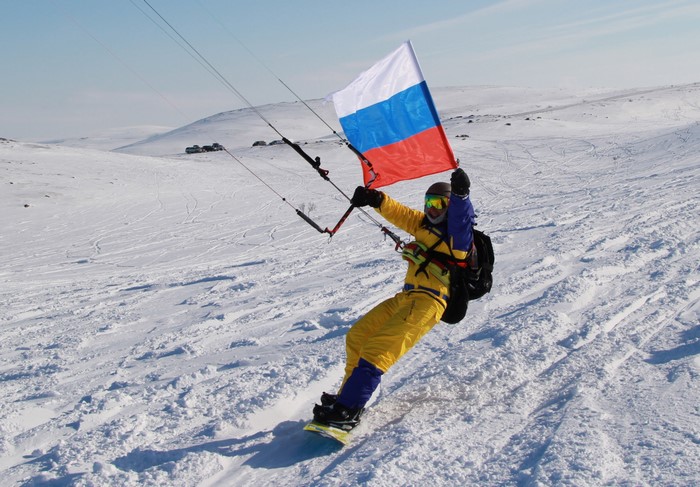 Snowkiter with Russian flag in winter landscape