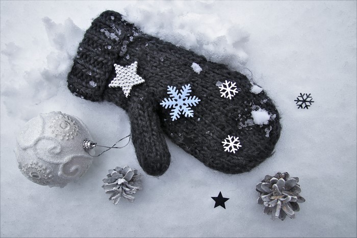 Winter scene with mitten, ornament, and pinecones