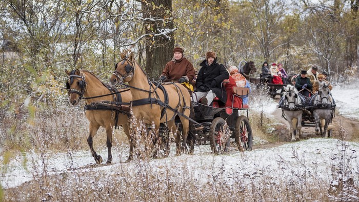 People in horse-drawn carriages in a snowy landscape
