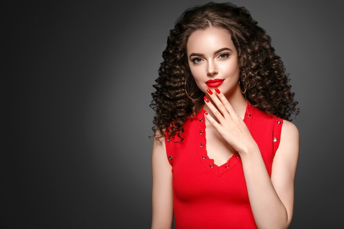 Woman with curly brown hair and red dress