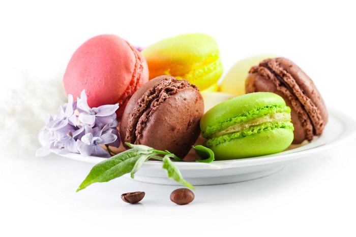 Macarons on a plate with flowers and coffee beans