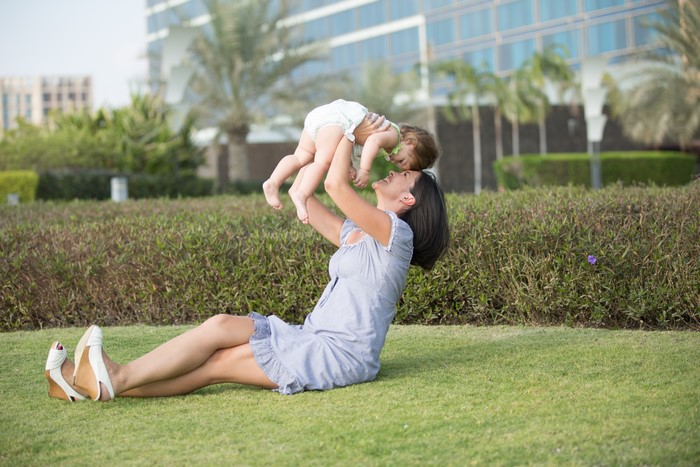 Mother holding infant in a park