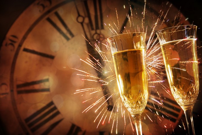 Champagne glasses with clock and fireworks