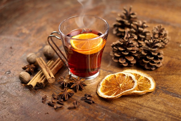 Hot drink with orange, cinnamon, star anise, and pine cones