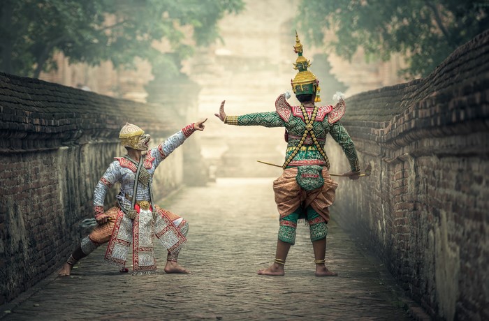 Two masked dancers in traditional costumes performing