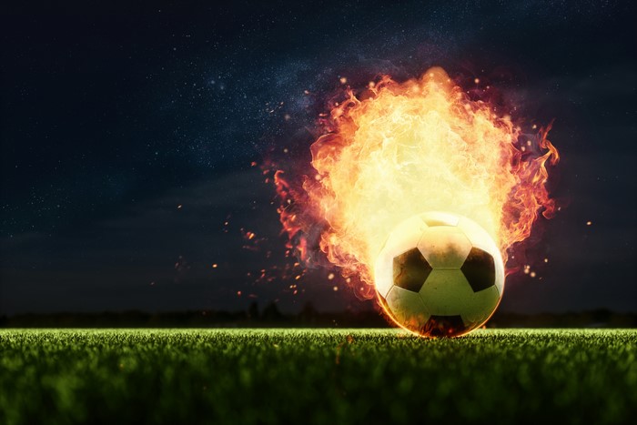 Soccer ball on fire on a field at night