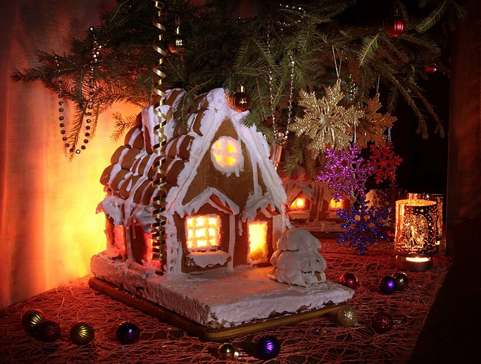 Gingerbread house and Christmas decorations under a tree