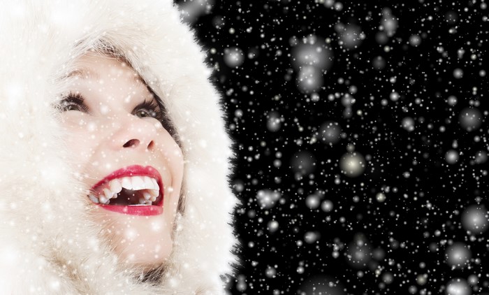 Woman in fur hood with red lips in snow