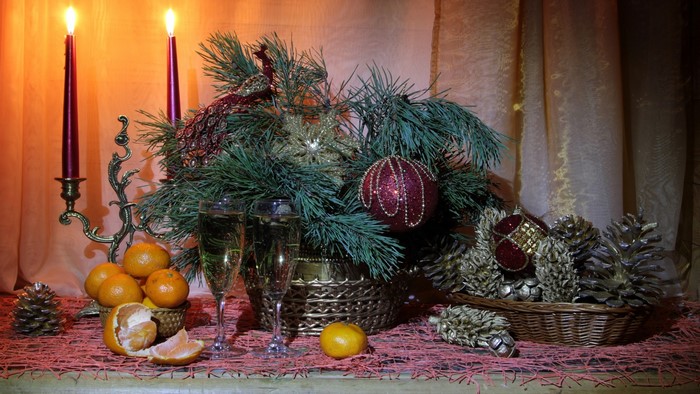 Christmas still-life with tangerines, champagne, and candles