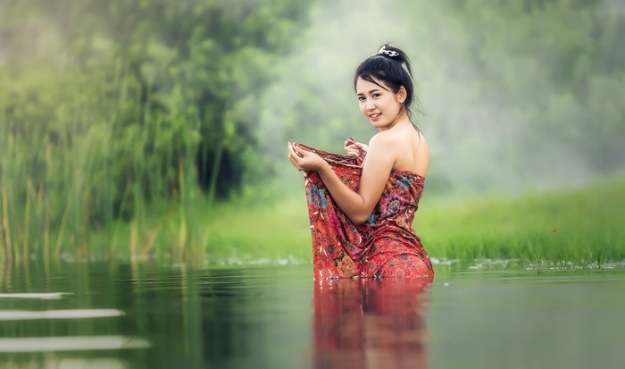 Brunette Woman in Water with Green Grass Background