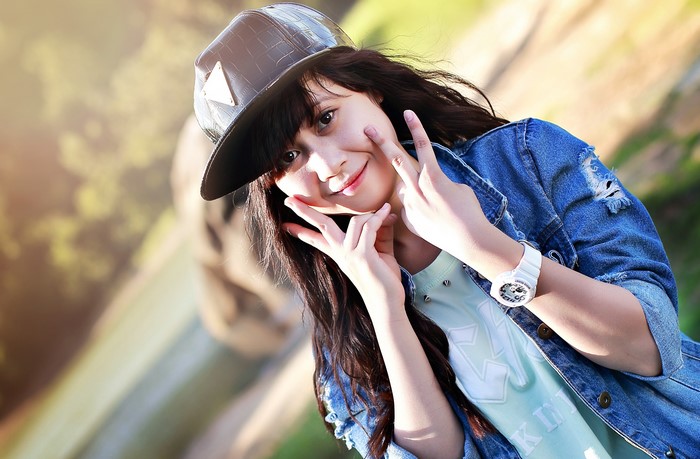Brunette girl in baseball cap and denim jacket