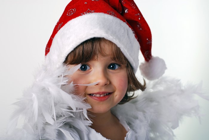 Little girl in Santa hat with white feathers