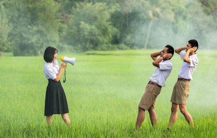 Girl with Megaphone and Two Boys Covering Ears