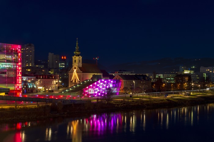Linz, Austria at Night with Illuminated Buildings and Church