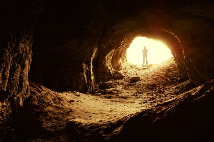 Silhouette of a person at the entrance of a cave