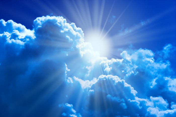 Sun shining through clouds in a blue sky