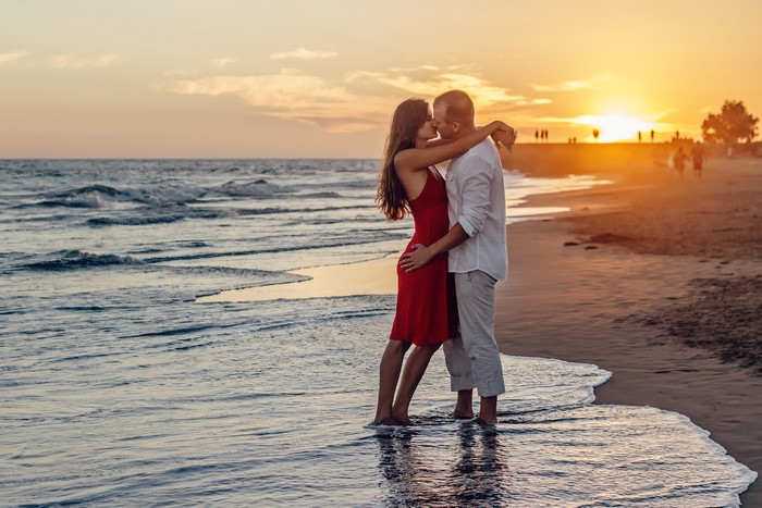 Couple kissing on a beach at sunset