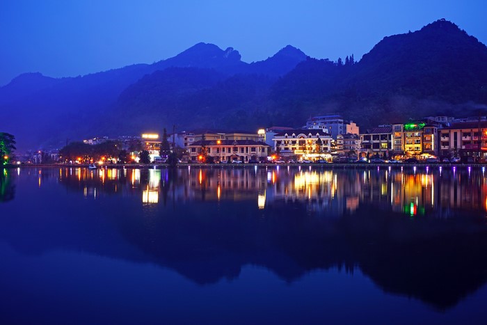 Town on a lake at dusk with mountains