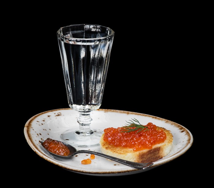 Vodka with caviar on toast and spoon on plate