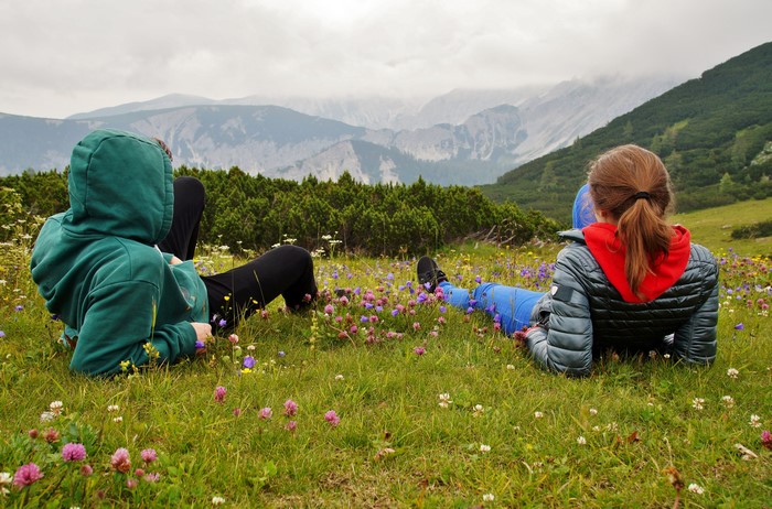 Two people resting in a mountain meadow in Austria