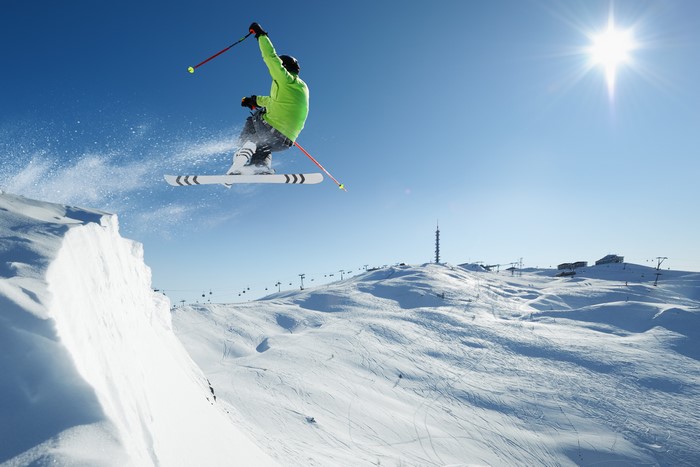 Man skiing and jumping off a snowy cliff