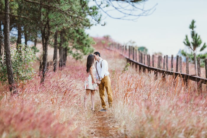 Couple kissing on a grassy trail