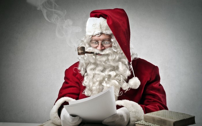 Santa Claus smoking a pipe and reading
