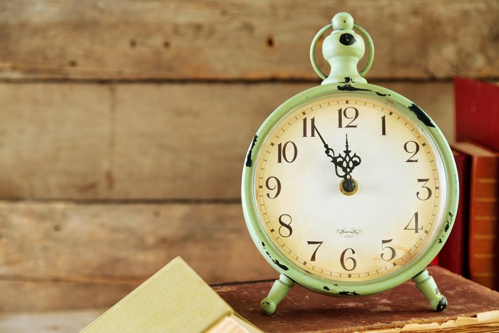 Green alarm clock on books