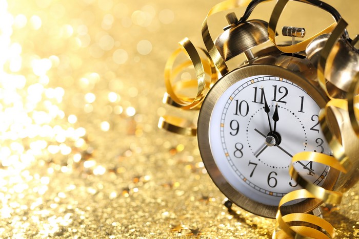 Alarm clock with gold streamers on a glittery background